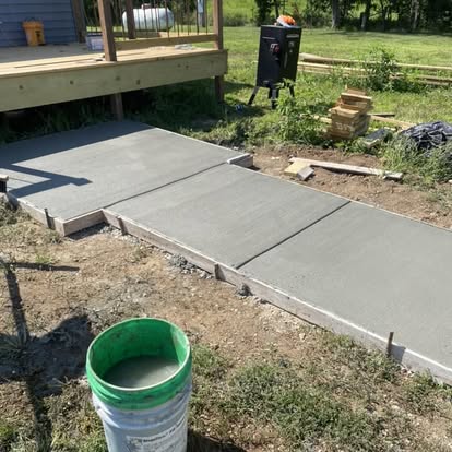 Concrete walkway alongside backyard deck